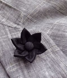 A black silk lapel pin flower boutonniere for elegant men and women, made in the Japanese tsumami kanzashi style! I used a black dupioni silk to make the flower, added a cover button to the center, and mounted it on a tie tack with butterfly clutch back. Complements a suit, blazer, vest, hat, or sports jacket. Kanzashi flowers are made from folded fabric squares, one petal at a time. Originally, apprentice geisha made kanzashi hair accessories from their old kimonos. DETAILS  ---dupioni silk ... Classic Black Lapel Pin For Formal Occasions, Elegant Formal Brooches With Handmade Flowers, Elegant Black Business Lapel Pin, Black Brooches With Handmade Flowers For Gift, Handmade Flower Black Brooches For Gifts, Handmade Flowers Black Brooches For Gift, Black Formal Brooch Lapel Pin, Classic Black Brooches For Formal Occasions, Handmade Flower Shaped Brooches For Formal Occasions