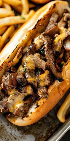 a close up of a hot dog with cheese and mushrooms on it next to french fries