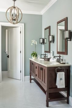 a bathroom with two sinks, mirrors and lights on the wall next to each other