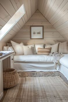 a bed sitting under a window in a bedroom next to a rug on top of a wooden floor