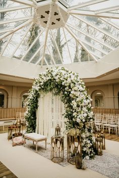 an indoor wedding setup with white flowers and greenery