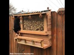 there is a large wooden box with lots of nuts in it on the side of a fence