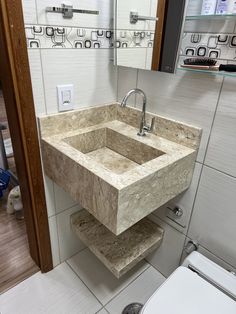 a bathroom sink sitting under a mirror next to a toilet