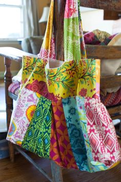 a multicolored bag hanging from a wooden pole in front of a chair and window