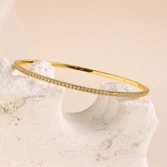 Our Classic Diamond Tennis Bangle is a dainty gold piece adorned with sparkling pavé stones, exuding elegance and sophistication. Perfect for any occasion, this versatile bracelet can be worn alone for a subtle touch of glamour or stacked with other bracelets for a classy, layered look ♡ SKU: RR-BR065 Product Details Material: 18K Gold Over Brass Finish: 18K Gold Featuring ~2.5mm wide Diamond Bangle Bracelet with CZ Pavé Diamond Stones Featured Styles Part of our Diamond & Pavé Collection Model Bracelet Tennis, The Bangles, Diamond Bangles Bracelet, Stone Feature, Gold Piece, Diamond Bangle, Layered Look, Tennis Bracelet, Diamond Stone