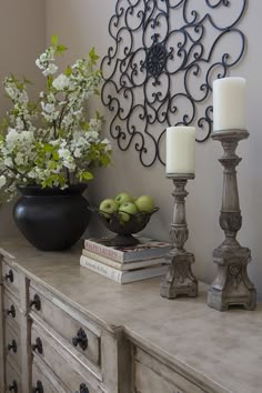 a table topped with books and candles next to a vase filled with flowers on top of it