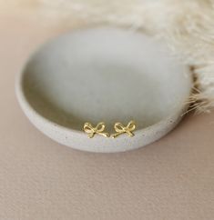 These beautiful bow stud earrings are beautiful on their own or make a great addition to any ear stack! These earrings are available in gold vermeil (18k gold plating over sterling silver) or sterling silver and are great for sensitive ears! Check out our other earrings here: https://www.etsy.com/shop/satinstitchdesigns?ref=l2-shopheader-name§ion_id=23495161 PLEASE NOTE: All of my items are custom made. The colors on your monitor may differ slightly from the color delivered. Please read my shop Cute Gold Earrings For Mother's Day, Cute Gold Bow Earrings, Cute Gold Sterling Silver Earrings, Cute Anniversary Jewelry With Bow, Small Gold Cute Earrings, Cute Bow Earrings For Gifts, Ear Stack, Hypoallergenic Jewelry, Bow Earrings