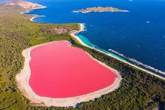 an aerial view of a pink lake surrounded by water