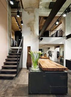 the interior of a modern loft with stairs and large mirror on the wall above it