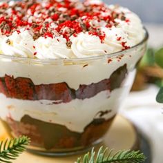 a close up of a cake in a glass dish on a table with pine branches