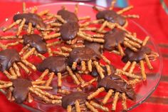 chocolate covered pretzels are arranged on a glass platter with red table cloth