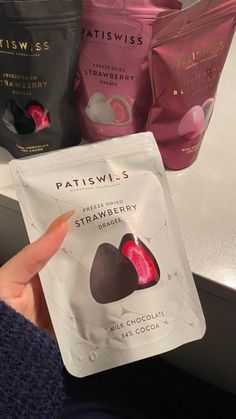 a person holding up a packet of patiswis's fruit and nutritious chocolate