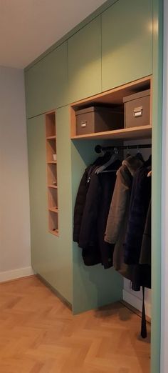 an empty closet with clothes hanging on the wall and two bins full of coats