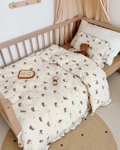 a teddy bear sitting on top of a bed in a room with white walls and beige carpet