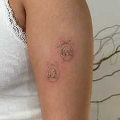 a woman's arm with two small tattoos on the left side of her arm