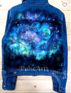 a denim jacket with galaxy painted on it