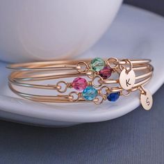 This listing is for 1 stackable bangle bracelet with optional initial charms.  A 6mm Swarovski Crystal is wrapped in 14k gold filled wire is the centerpiece of this handmade bangle.  Each bangle is formed from 14k gold filled wire and then hammered and tumbled for shine and strength. Each bracelet is hand formed and unique and not perfectly circular which lends to it's organic charm.  Let me know the birthstone choice in the text box.Choose from the following Swarovski Crystals: January - Garnet Birthstone Bangle Bracelets For Gifts, Nickel-free Crystal Bangle Bracelet For Gift, Adjustable Bangle For Birthday, Stackable Round Bracelets For Birthday, Gold Birthstone Bracelet, Bridesmaid Bracelet Gift, Bangle Bracelet Gold, St Michael Pendant, Bff Jewelry