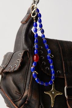 The perfect blend of two of our favorite accessories, this stand-out bag charm is featured in a beaded necklace style with defined metal pendant for the ideal finishing touch. | Beaded Necklace Bag Charm by Free People in Blue Beaded Purse Charms, Bag Necklace, Phone Charms, Beaded Bag, Bag Charms, Beaded Purses, Purse Charms, Beaded Bags, Jewelry Inspo