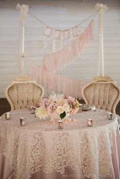 a table with two chairs and flowers on it