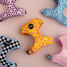 several different dog toys are arranged on a pink surface with black and white checkers