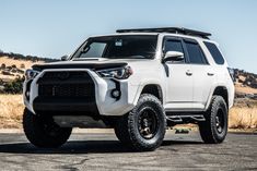 a white toyota 4runner is parked on the road