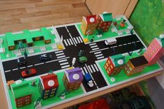 a toy city with cars and buildings on the road is shown in this playroom