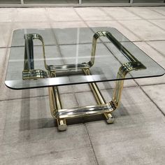 a glass and metal coffee table on the ground