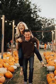 a man carrying a woman on his back among pumpkins