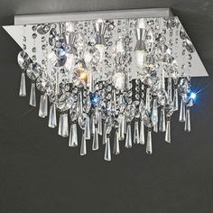 a crystal chandelier hanging from the ceiling in a room with black walls and flooring