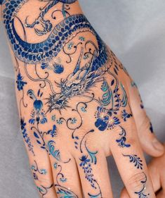 a person's hand with tattoos on it and a dragon tattooed on the palm