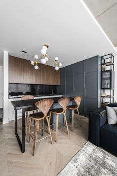 an open kitchen and living room are shown in this modern style apartment with wood accents