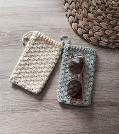 two crocheted items sitting on top of a wooden table