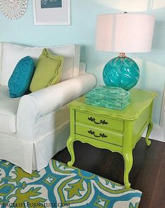 a living room with blue and green accents on the walls, white furniture and rugs