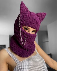 a woman wearing a purple knitted cat mask with chains around her neck and eyes