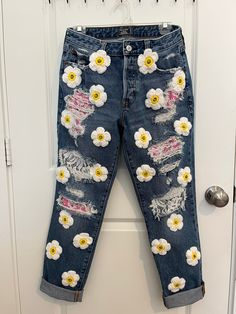 a pair of jeans with flowers painted on them