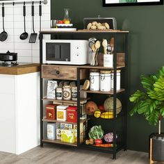 a kitchen with green walls and wooden shelves filled with food, utensils and other items