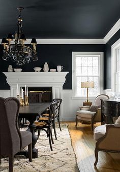 the dining room is decorated in black and white with an antique chandelier hanging from the ceiling