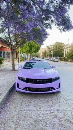 the purple car is parked on the side of the road