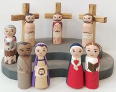 a group of wooden figurines sitting on top of a round table with crosses above them