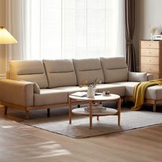 a living room with a couch, coffee table and lamp on the side of the wall