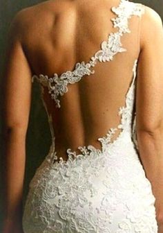 the back of a woman's wedding dress with an open back and lace detailing