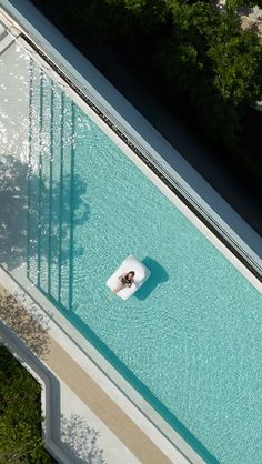 an aerial view of a swimming pool with people in it