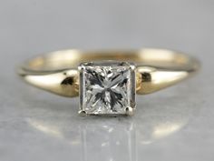 a yellow gold engagement ring with a princess cut diamond