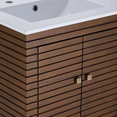 a bathroom vanity with a white sink and brown wood paneling