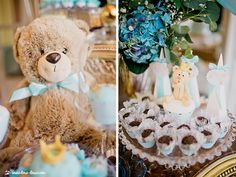 a teddy bear sitting on top of a table next to cakes and cupcakes