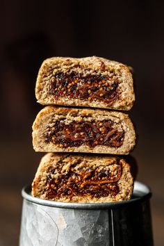 three bars stacked on top of each other in a metal container, with nuts and raisins