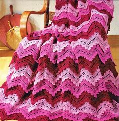 a crocheted blanket sitting on top of a wooden chair