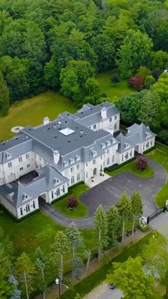 an aerial view of a large house surrounded by trees