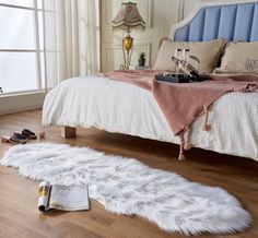 a bedroom with a bed, pillows and rugs on the floor next to it