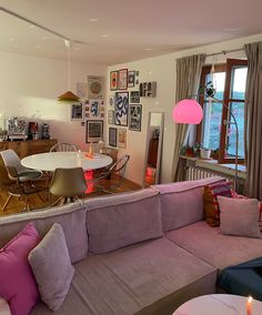 a living room filled with furniture next to a dining room table and chairs on top of a hard wood floor